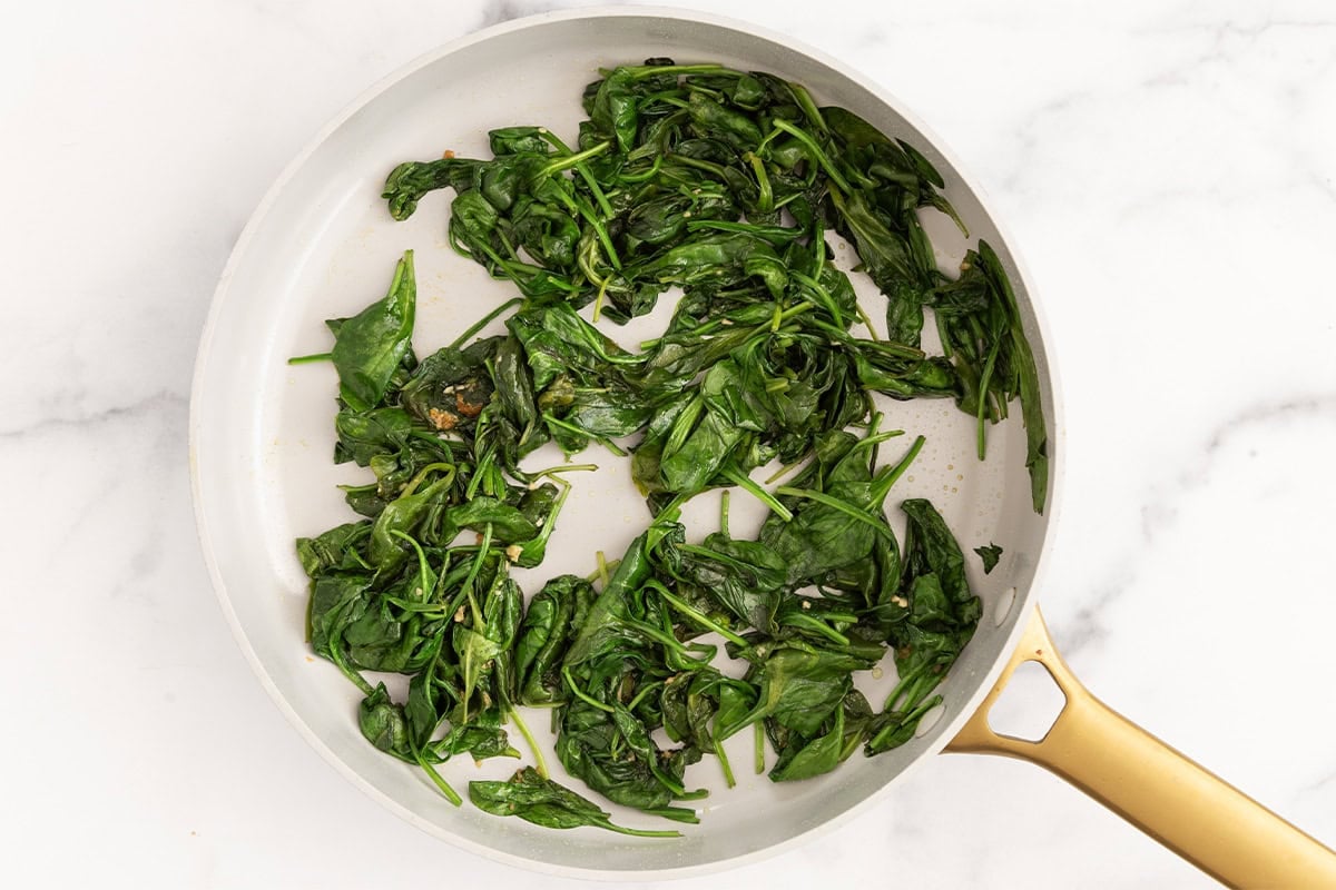 Cooked spinach in pan for spinach pasta sauce.