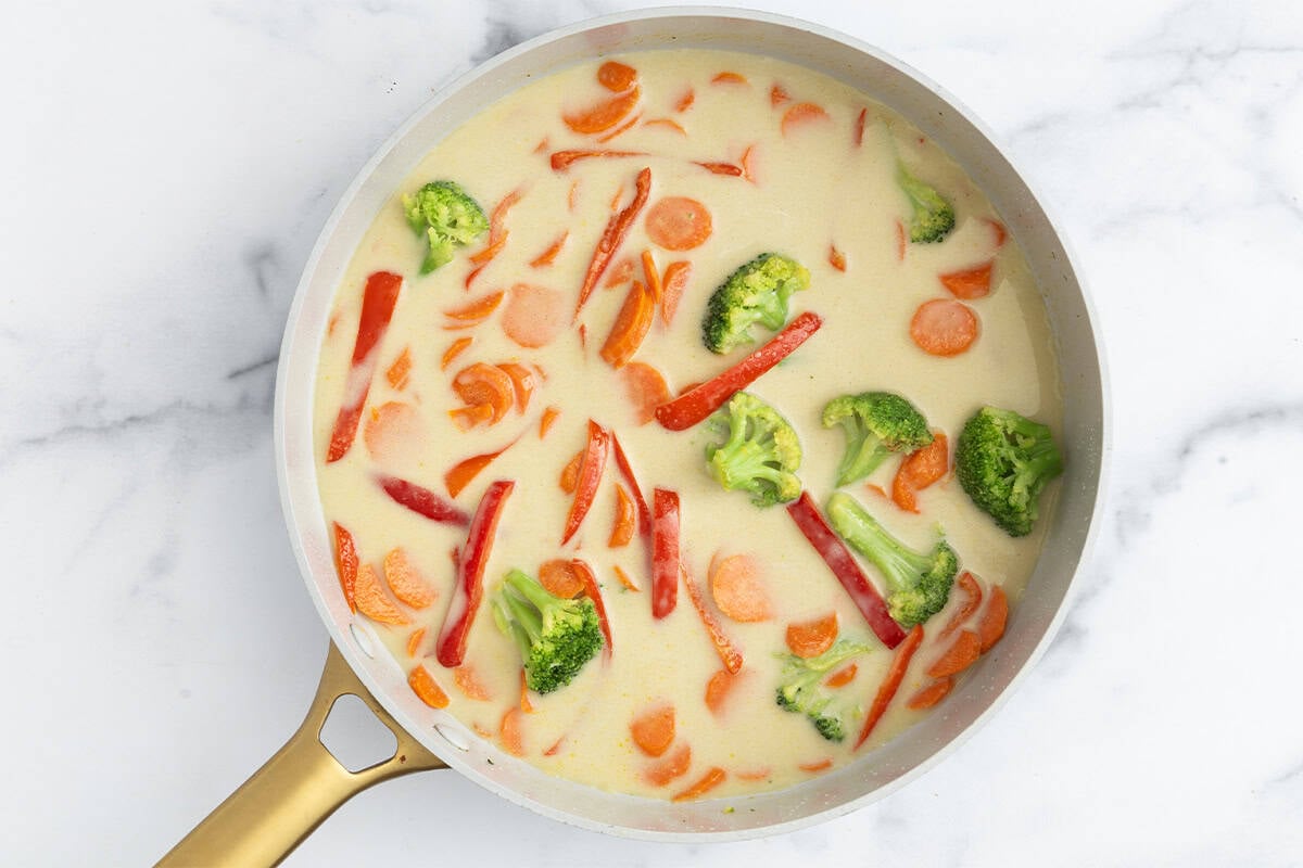 Green curry in pan cooking before adding tofu.