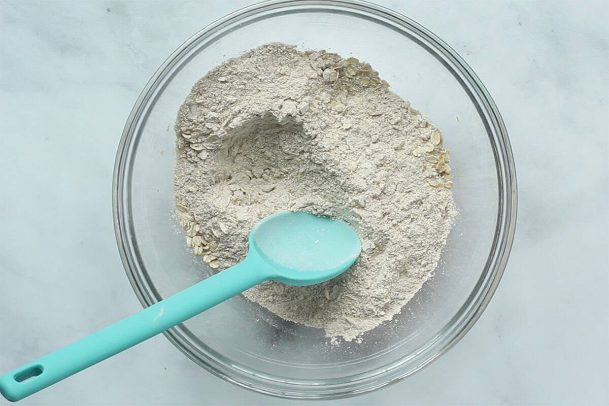 Dry ingredients for strawberry muffins in glass bowl. 