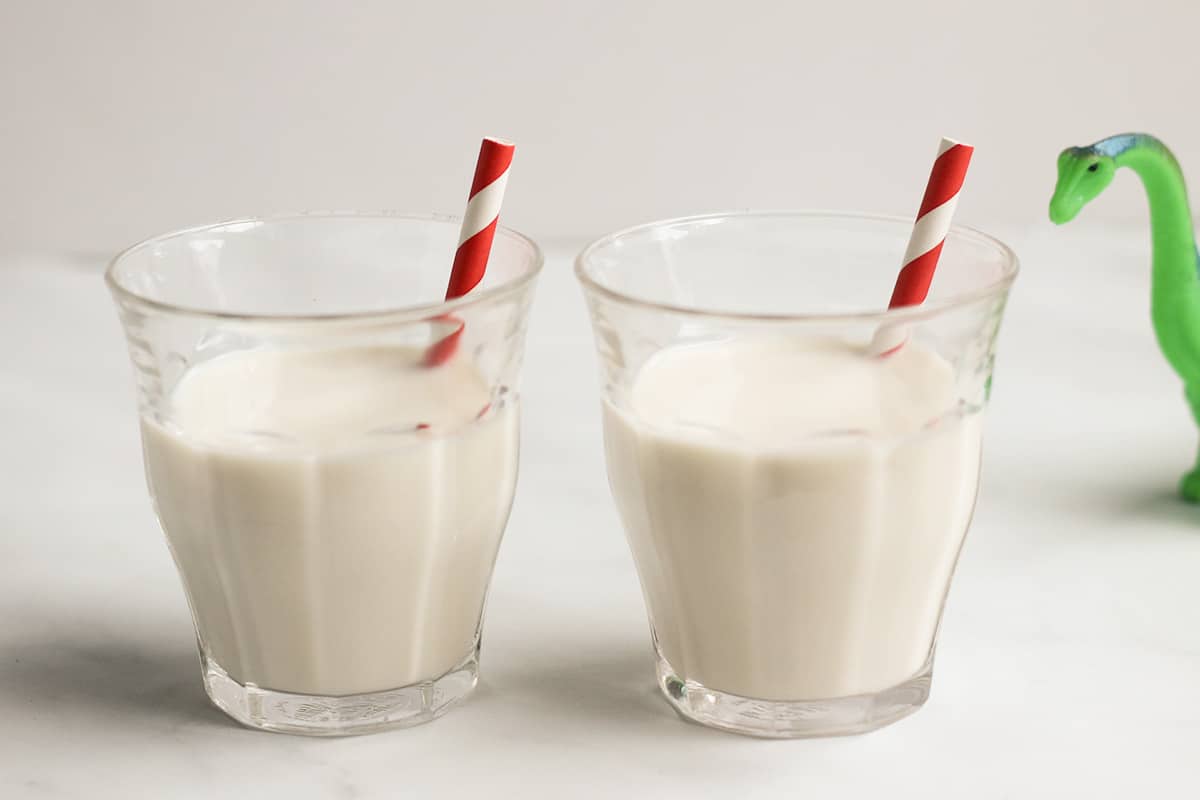 vanilla milk in two cups with red paper straws.