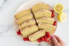 Sliced lemon yogurt cake on plate with berries.