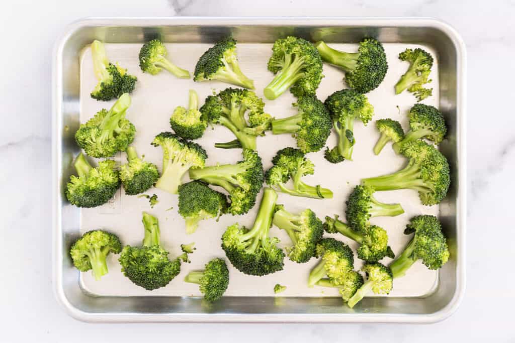 broccoli florets with olive oil on cutting board.