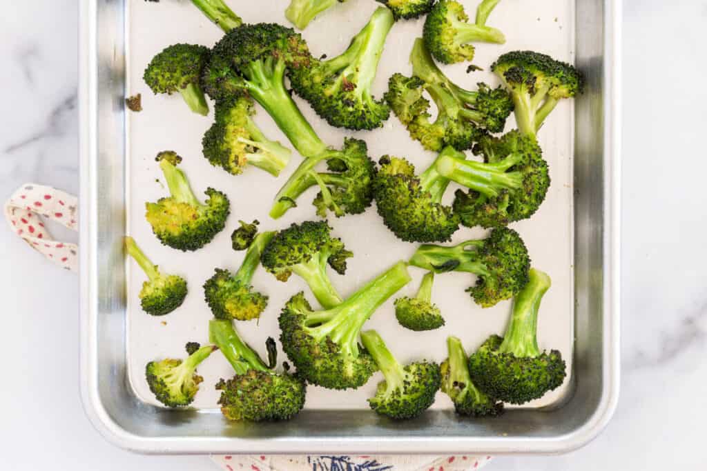 baked roasted broccoli on baking tray.