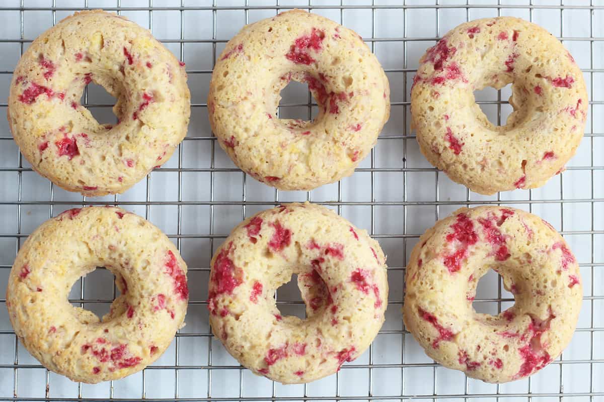 baked raspberry donuts on wire rack.