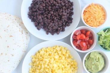 taco buffet ingredients in bowls on counter.