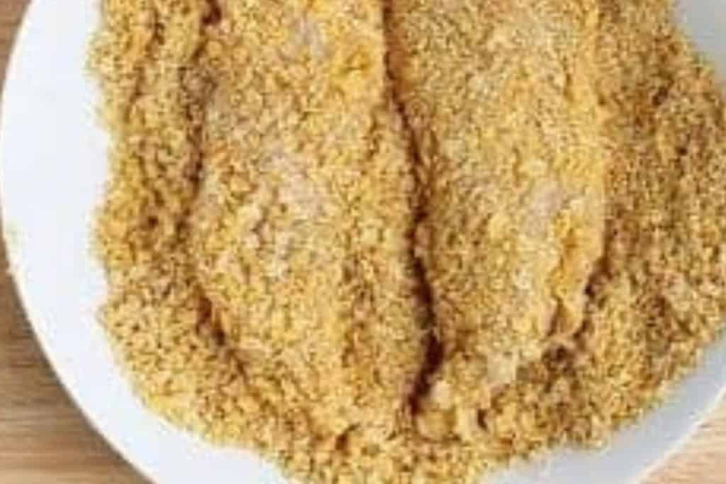 baked chicken tenders being drenched in coating.