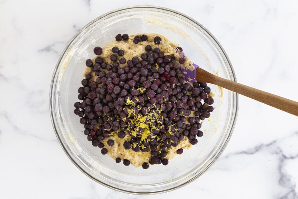 blueberry yogurt muffin batter with blueberries in glass bowl.