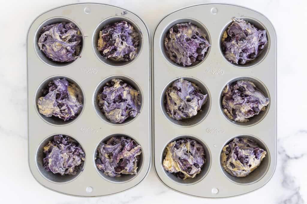 blueberry yogurt muffin batter in muffin pans.