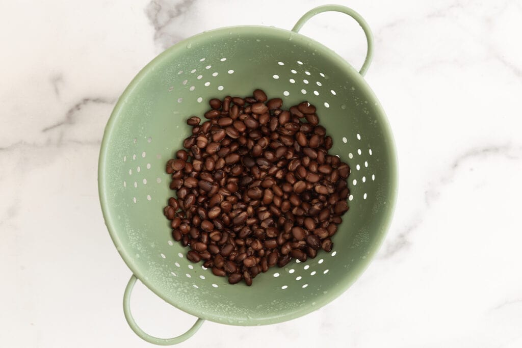 black beans in green colander.