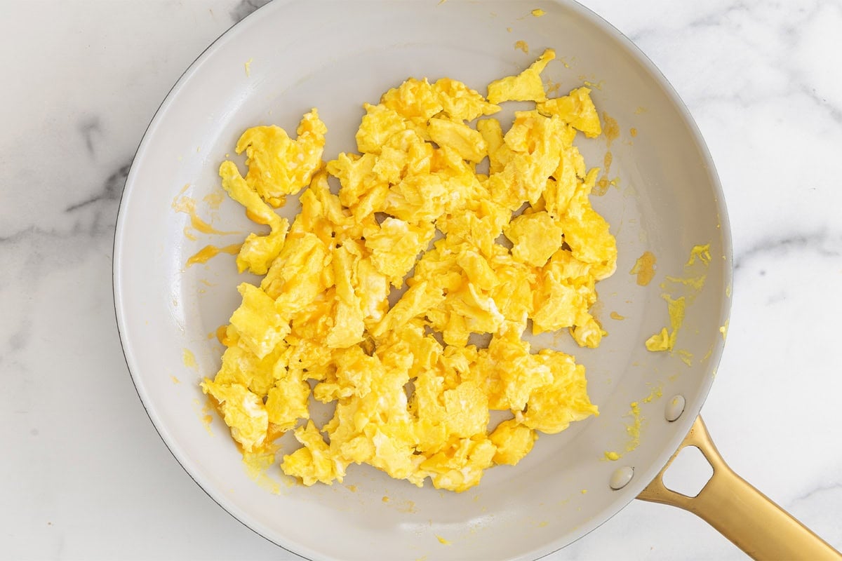 scrambled eggs in white pan.