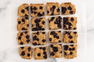 oatmeal bars with blueberries on parchment paper.