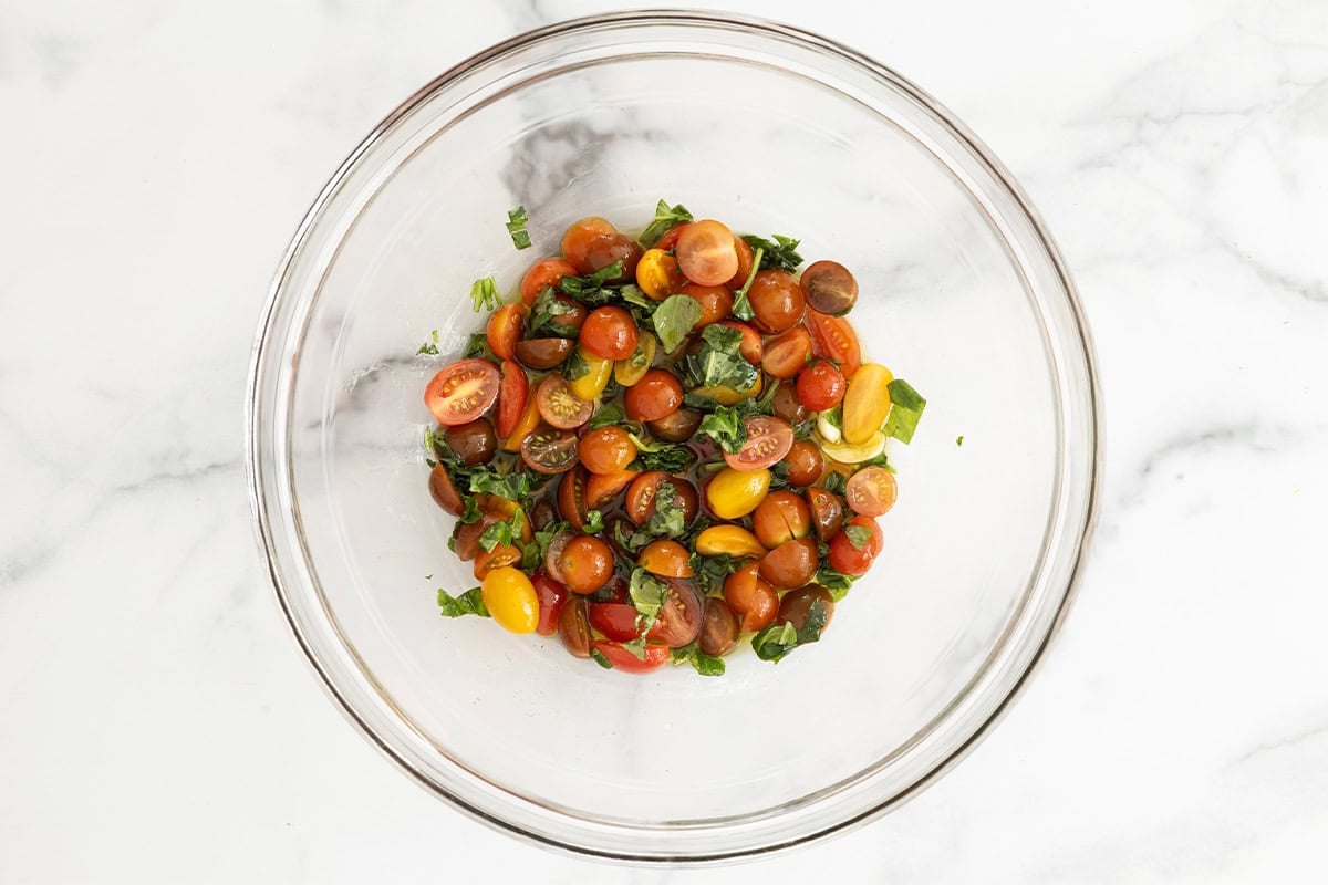 Tomatoes and basil in glass bowl for pasta salad with chicken. 