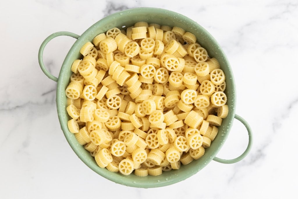 Noodles in strainer for pasta salad with chicken.