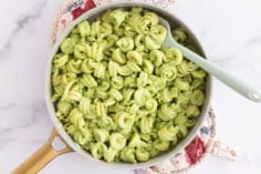 Pasta with pea sauce in pan with spoon.