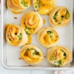 Broccoli cheese pinwheels on baking sheet.