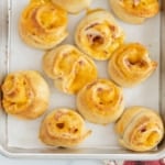 Ham and cheese pinwheels on baking sheet.