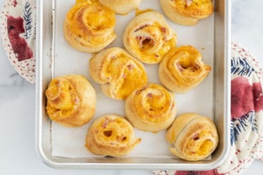Ham and cheese pinwheels on baking sheet.