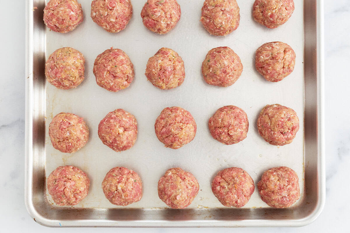 Sausage meatballs on baking sheet before baking.