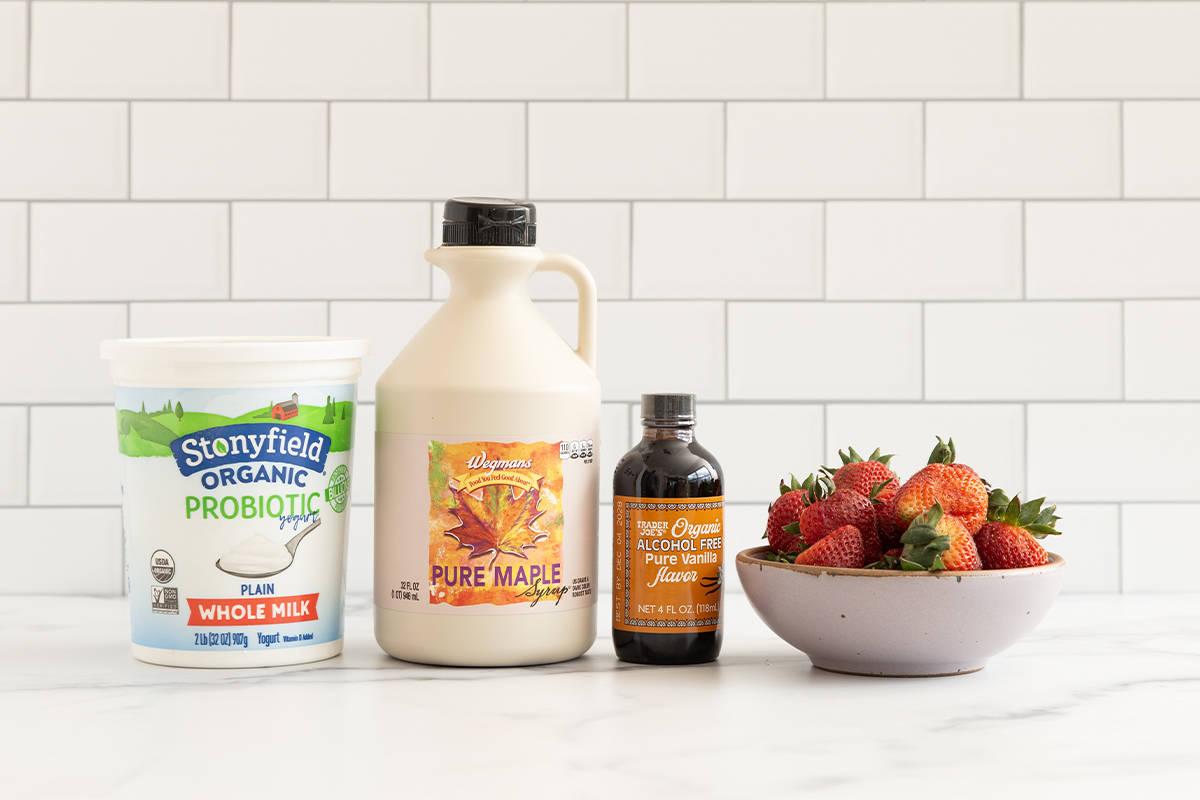 Ingredients for strawberry yogurt on countertop.