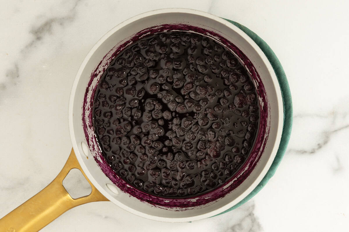 thickened blueberries in juices in pan on counter.