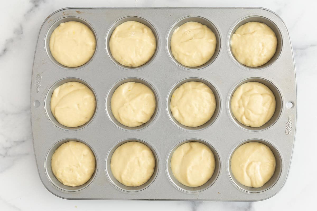 lemon yogurt muffin batter in muffin pan.