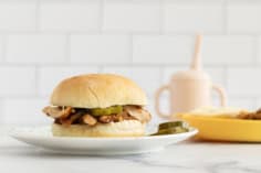 Instant pot bbq chicken sandwich on plate with sides.