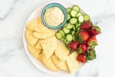 Yogurt flatbread on plate with dip and sides.