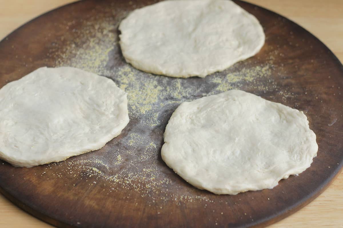 dough for pesto pizza on pizza stone.