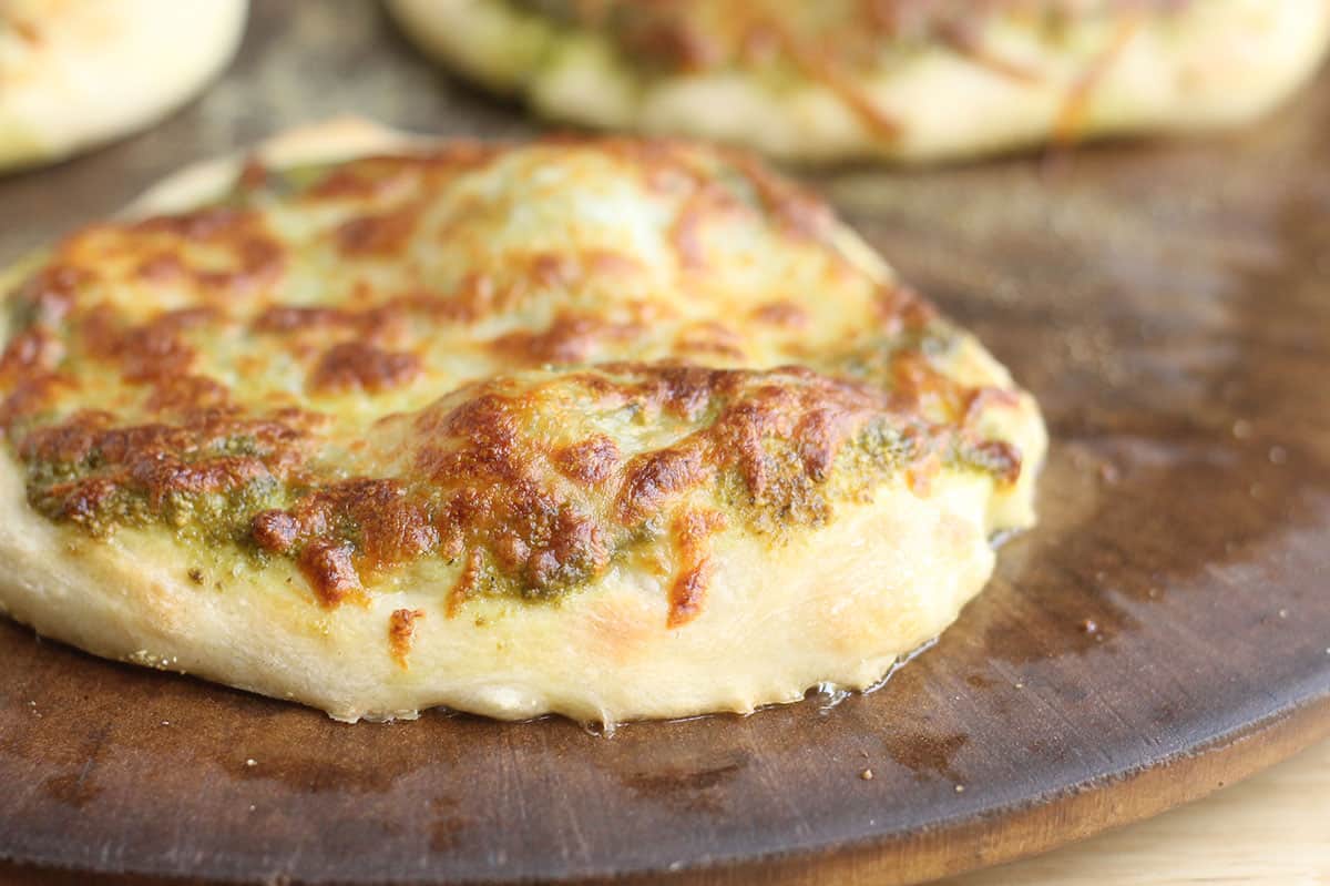 baked pesto pizza on pizza stone.