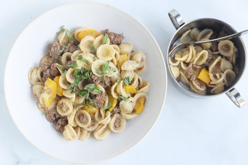 pasta with summer squash in bowls on counter.