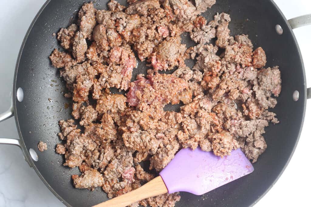 browning meat in black pan.