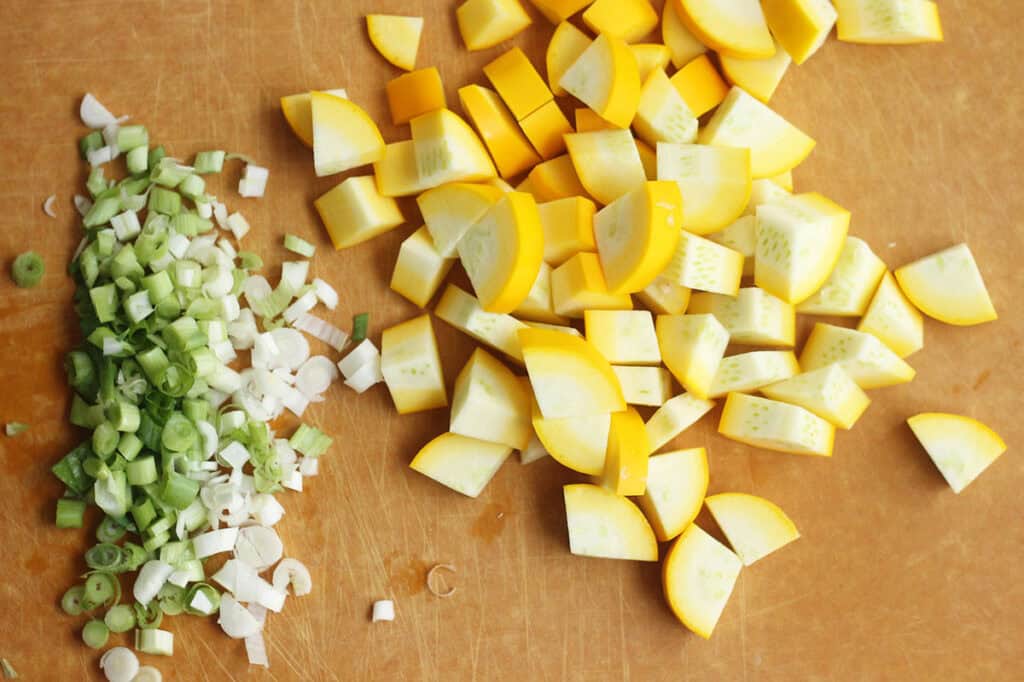 diced onion and summer squash on cutting board.