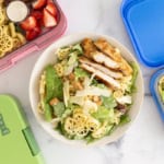 chicken caesar pasta salad in bowl and lunch boxes.