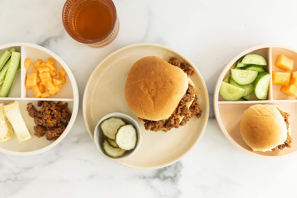 sloppy joes on three plates with sides.