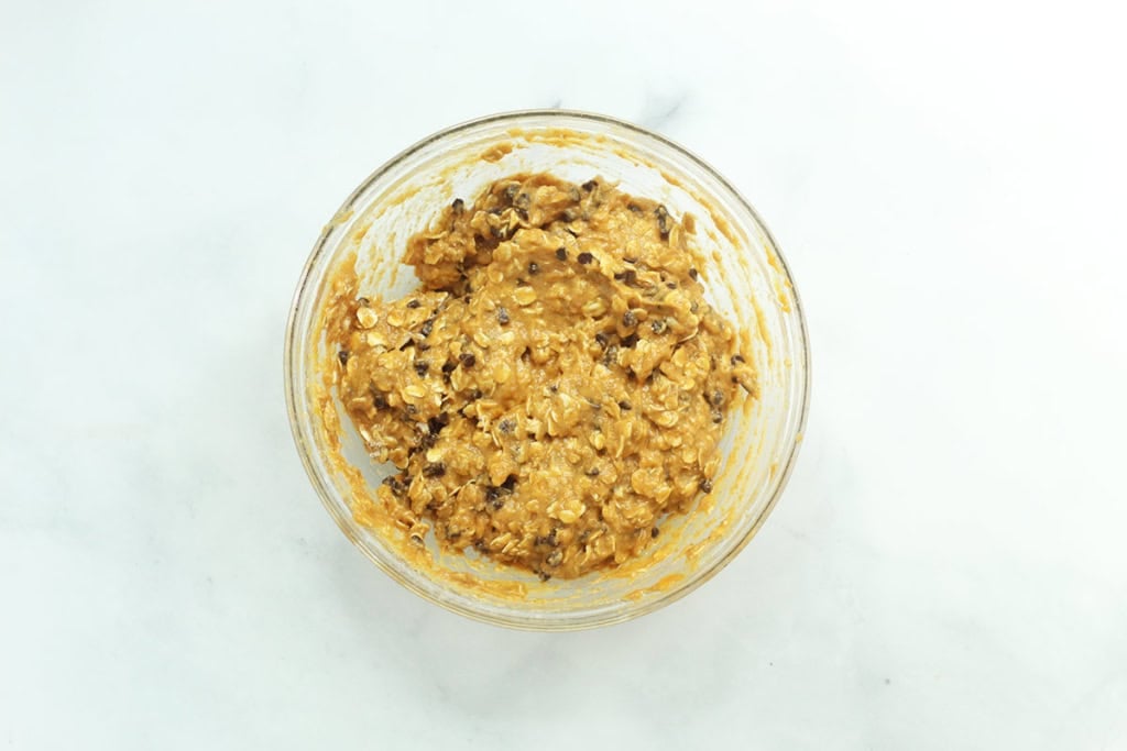 Batter in glass bowl for pumpkin chocolate chip muffins.
