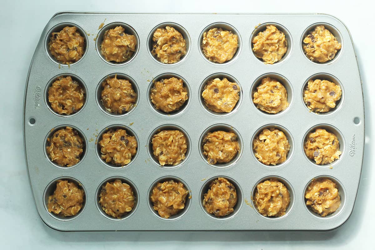 Pumpkin chocolate chip muffins in mini muffin pan before baking.