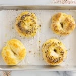 Four bagels on baking sheet after baking.
