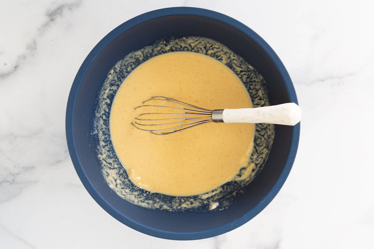 Wet ingredients in blue bowl for pumpkin protein pancakes.