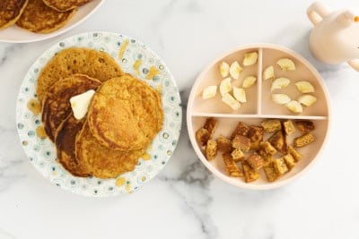 Pumpkin protein pancakes on two plates with sides.