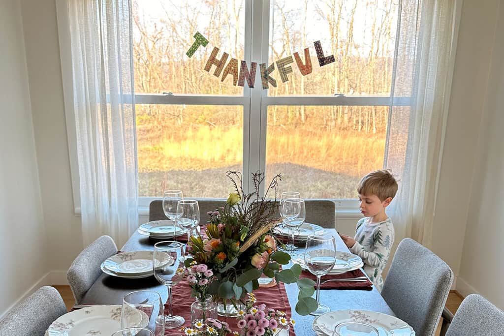 thankful banner behind table with boy.