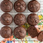 Double chocolate muffins on cooling rack with one cut open.