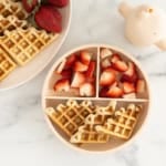 Vegan waffles on kids plate with strawberries.