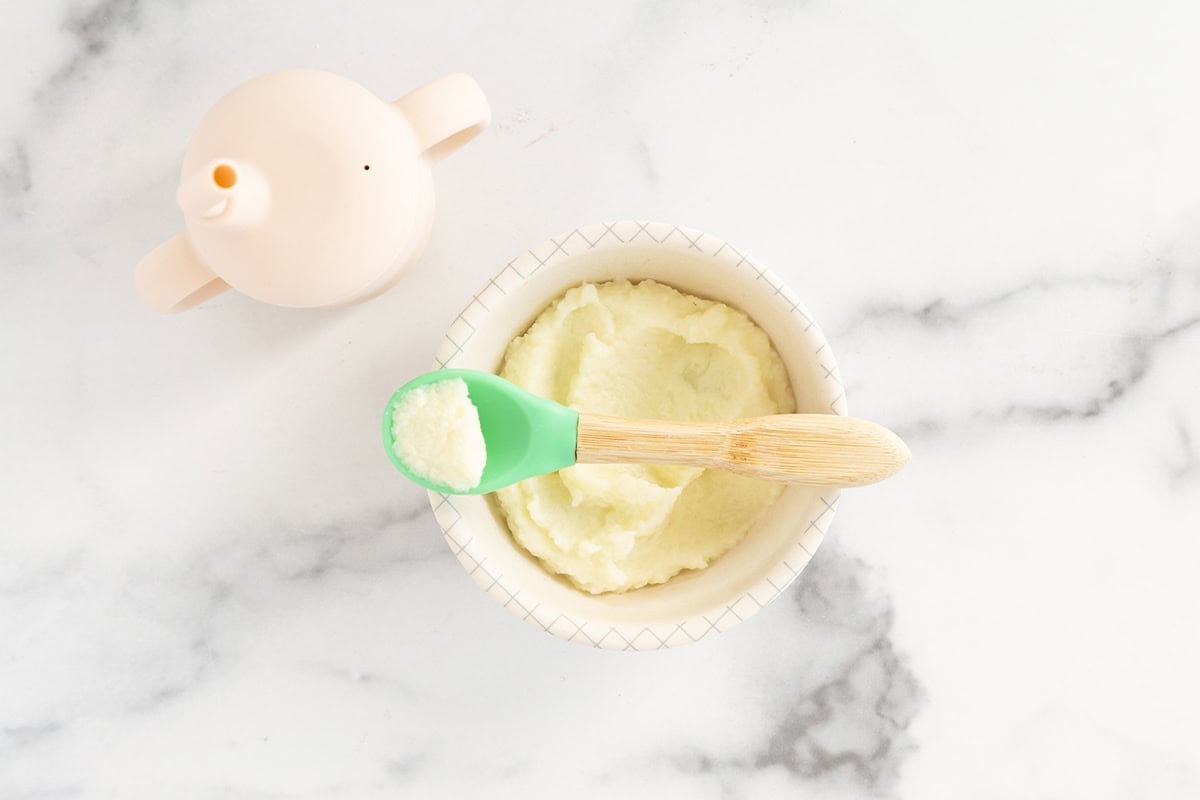 Cauliflower baby food in bowl with spoon.