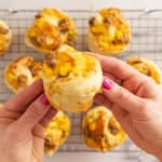 Hands holding breakfast pizza roll.