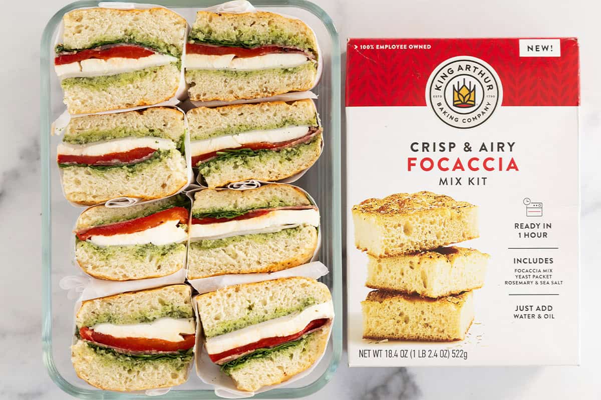 container of focaccia sandwiches next to focaccia baking mix box.