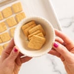Peanut butter crackers in white bowl with hands holding it.