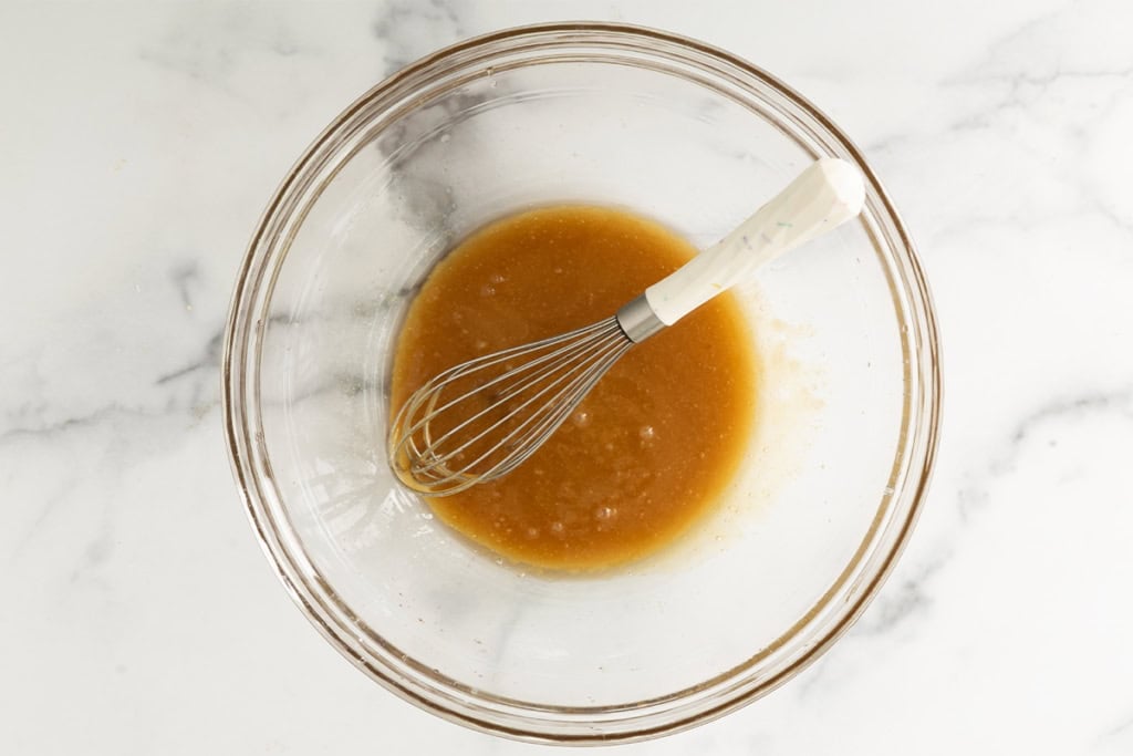 Wet ingredients in glass bowl for crunchy granola bars.