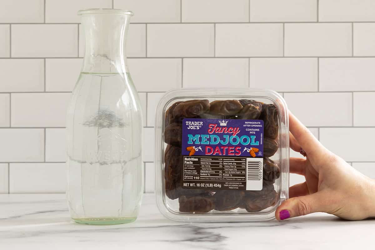 ingredients for date paste on counter with woman's hand.
