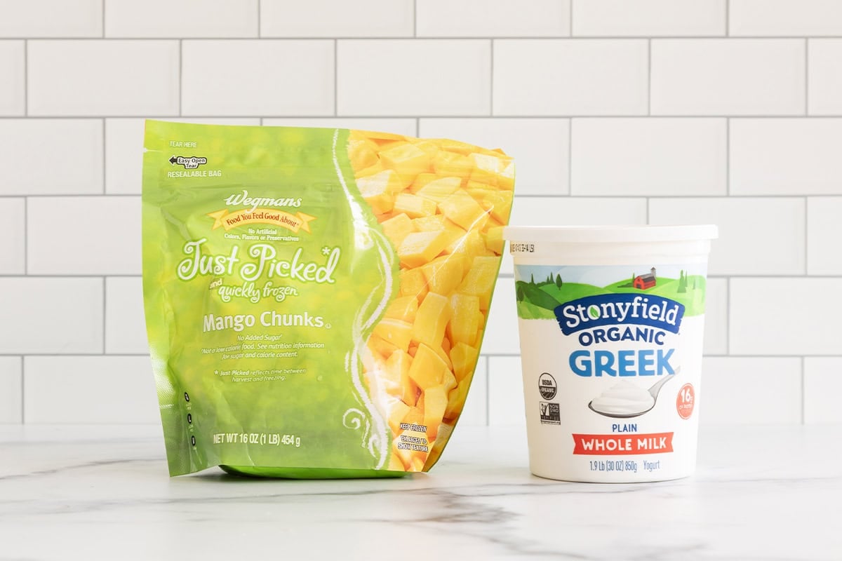 Ingredients for mango frozen yogurt on countertop.