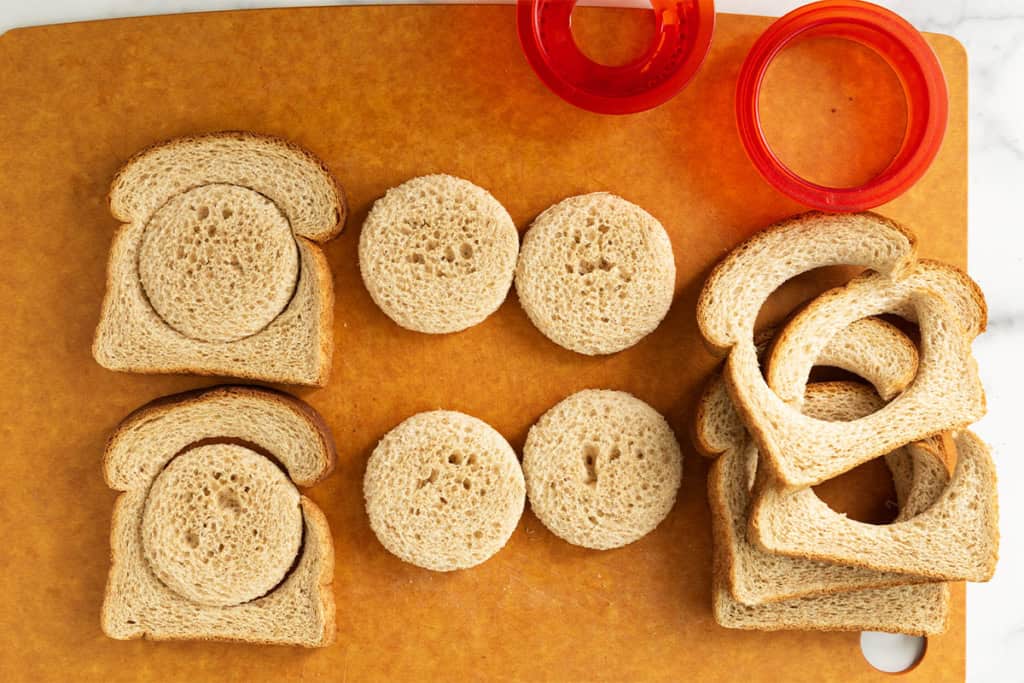 Cutting circles in bread for pizza uncrustables.